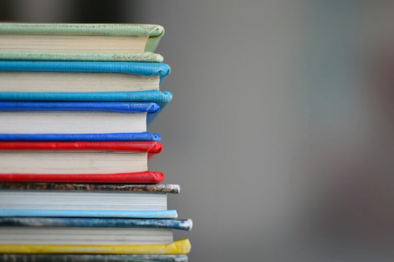 Une pile de livres colorés empilés, symbolisant l'apprentissage, la connaissance et la curiosité intellectuelle.