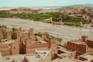 Kasbah traditionnelle au Maroc entourée de verdure et d'une rivière asséchée